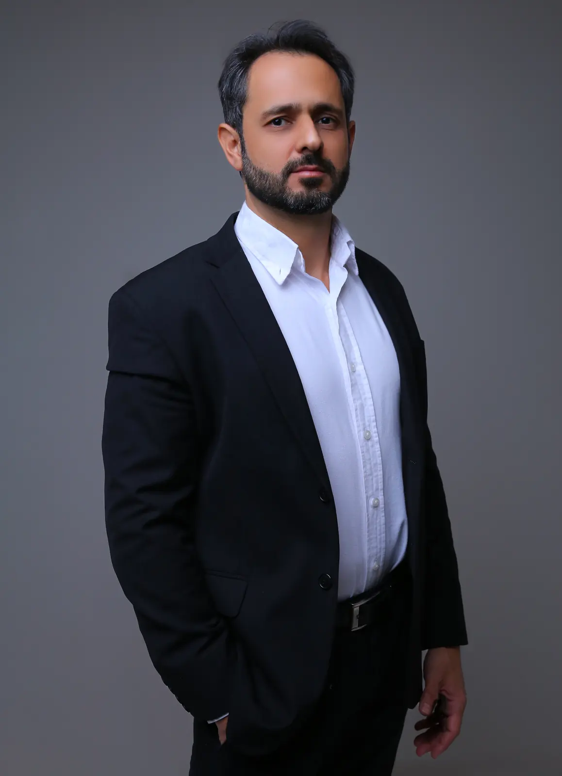Retrato do advogado Mauro Vieira, de terno preto e camisa branca, em pé, com a mão no bolso, olhando para a câmera.